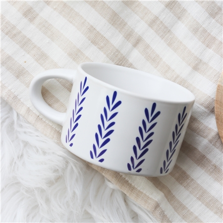 Weiße Tasse mit blauem Folklore-Dekor